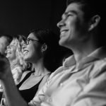 Couples laughing in audience at date night event